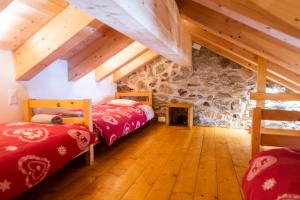 two beds in a room with a stone wall at Aiguille de La Tza in Arolla