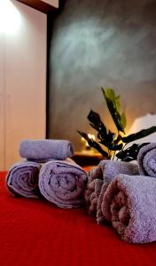 una pila de toallas sentadas encima de una cama en Ottimo appartamento " Pala Alpitour", en Turín