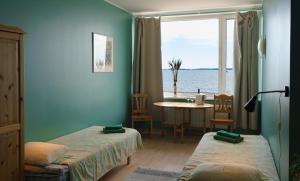Viinistu的住宿－維尼斯圖藝術酒店，客房设有两张床、一张桌子和一扇窗户。