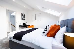 a bedroom with a bed with orange and white pillows at Hosta Group - Prestige 1 Bed Apartment - The Orange in Cambridge