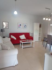 sala de estar con sofá rojo y mesa en APARTAMENTOS TURISTICOS LAS CINCO JOYAS, en Linares