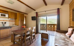 a kitchen and dining room with a table and chairs at Lagrange Vacances Les Chalets de l'Adet in Saint-Lary-Soulan