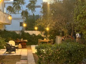 a garden at night with a bench and a table at Paola’s apartments near Athens Airport in Spáta