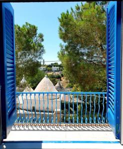 ein blaues Geländer auf einem Balkon mit Bäumen im Hintergrund in der Unterkunft Rifugio di Sibir in Selva di Fasano