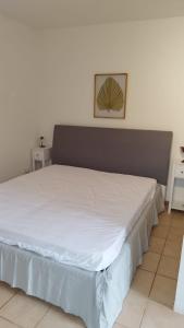 a bedroom with a large white bed with a picture on the wall at Villa tra gli ulivi in San Pietro in Bevagna