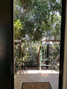 een open deur naar een houten terras met bomen bij Relaxing Experience in Chersonissos
