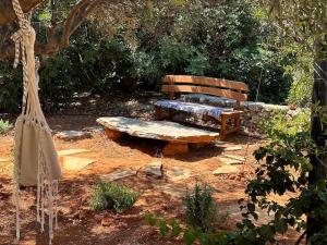 een houten bank in het midden van een tuin bij Relaxing Experience in Chersonissos