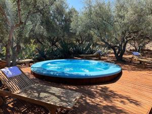 een hot tub op een terras met een bank en bomen bij Relaxing Experience in Chersonissos