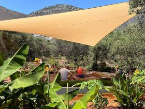 een groep mensen die onder een houten paraplu zitten bij Relaxing Experience in Chersonissos