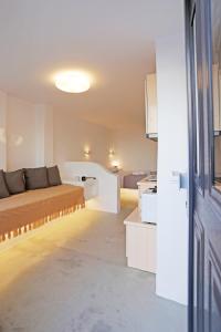uma sala de estar com uma cama e uma cozinha em Brand New Mykonos Town Suites em Míconos