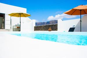 a swimming pool with two umbrellas on a house at Casa Chinija de Famara in Teguise