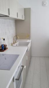 uma cozinha branca com um lavatório e um balcão em Victoire Saphir 203 climatisé hôtel de ville em Saint-Dizier