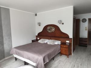 una camera con un grande letto con testiera in legno di Halo Kołobrzeg a Kołobrzeg