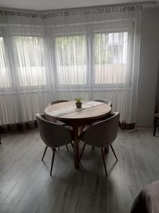 un tavolo con sedie in una stanza con finestre di Halo Kołobrzeg a Kołobrzeg