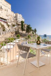einen Tisch und Stühle auf einem Balkon mit Blick auf den Strand in der Unterkunft Palazzo San Rocco Residenza Gentilizia in Sperlonga