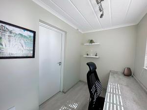 um quarto com uma cadeira preta e uma televisão em Sammy's Nest em Joanesburgo