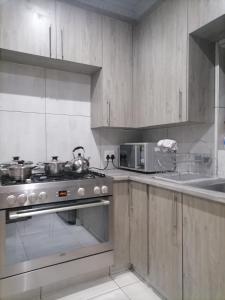 a kitchen with a stove and a microwave at Lady D Exclusive Abode in Polokwane