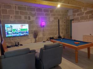 a living room with a pool table and a tv at Detente au pays de Lauzun in Saint-Colomb-de-Lauzun