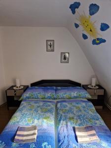 a bedroom with a bed with a blue comforter at Pension u Adršpachu - Dana Tyšerová in Janovice