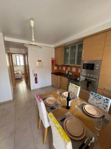a kitchen with a wooden table with plates on it at Apartamento Familia Silva in Nazaré