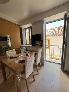 a kitchen with a wooden table with chairs and a dining room at Apartamento Familia Silva in Nazaré