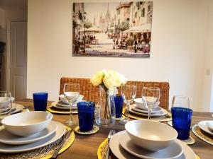 a wooden table with blue glasses and plates and flowers at Modern Home2Home - Easy Centre Access & Free Parking in Sheffield