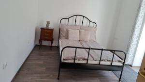 a bed with a metal frame and pillows on it at Castellum Apartman in Keszthely