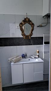 a bathroom with a white sink and a mirror at Castellum Apartman in Keszthely +7 photos