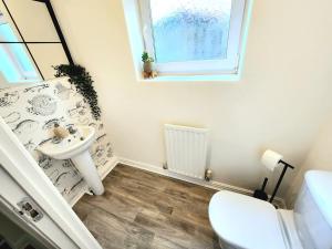a bathroom with a sink and a toilet and a window at Modern Home2Home - Easy Centre Access & Free Parking in Sheffield +31 photos