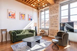 a living room with a green couch and a table at Le Cocon Pacôme Les Autres in Lyon