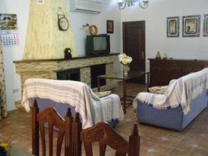 un salon avec deux chaises et une cheminée dans l'établissement Casa Rural el Pinar en Posadas Córdoba, à Posadas