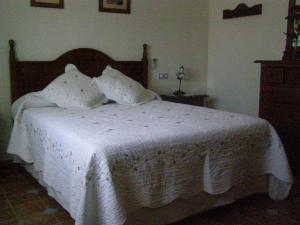 1 dormitorio con 1 cama con sábanas y almohadas blancas en Casa Rural el Pinar en Posadas Córdoba, en Posadas