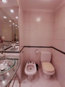 La salle de bains est pourvue d'un lavabo, de toilettes et d'un miroir. dans l'établissement Departamentos Ines 2, à Junín