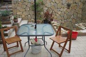 a glass table and two chairs on a patio at Castellum Apartman in Keszthely