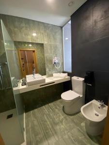 a bathroom with a toilet and a sink and a mirror at Hotel Pedras Salgadas in Pedras Salgadas