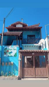 ein blaues Gebäude mit einem Tor davor in der Unterkunft POUSO DO BEIJA FLOR in Paraty