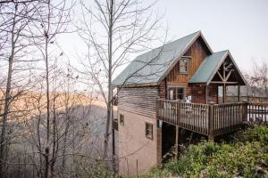 une maison en bois avec une terrasse sur une colline dans l'établissement Expansive Mountain Views, Theater, Games, Hot Tub, Relaxing porches, à Sevierville