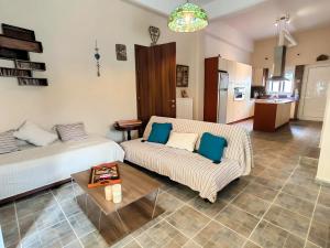 a living room with a bed and a couch and a table at Villa Nelparadi in Plátanos