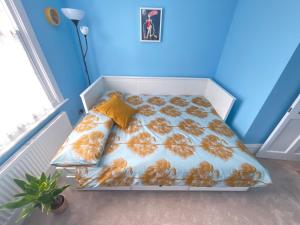 un letto in una camera con parete blu di Studio Pillo Hammersmith a Londra