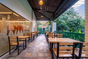 uma fila de mesas e cadeiras num restaurante em Palette - Coastal Grand Hotels & Resorts, OMR em Chennai