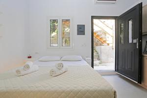 a white bedroom with a bed with towels on it at Brand New Mykonos Town Suites in Mikonos