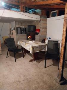 Zimmer mit einem Tisch, 2 Stühlen und einem TV in der Unterkunft Kaj Nana i Dedo in Skopje