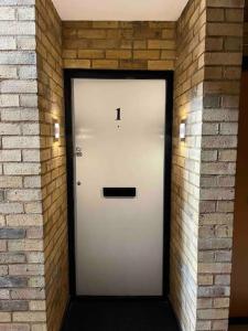 una puerta blanca en una pared de ladrillo en Newly Refurbished Apartment with private parking en Southampton