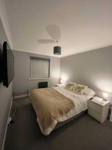 サウサンプトンにあるNewly Refurbished Apartment with private parkingのベッドルーム1室(ベッド1台、ランプ2つ、テレビ付)