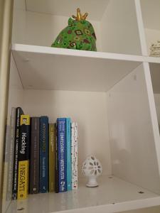 a shelf with books and a green clock on it at CASA VACANZE : CASA FORTUNA in Taranto