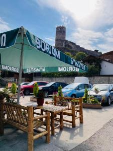 a picnic table and an umbrella in a parking lot at Old Rabati in Akhaltsikhe