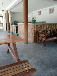 sala de estar con mesa de madera y bancos en Sri Lanka Surf Villa Domus Graziella en Ahangama