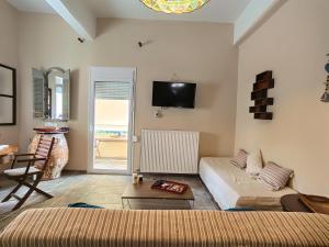 ein Wohnzimmer mit einem Bett, einem Sofa und einem Tisch in der Unterkunft Villa Nelparadi in Plátanos