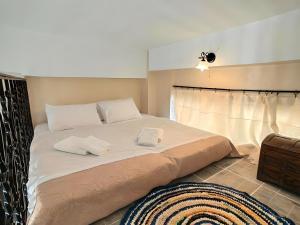 1 dormitorio con 1 cama grande y 2 toallas. en Villa Nelparadi, en Plátanos