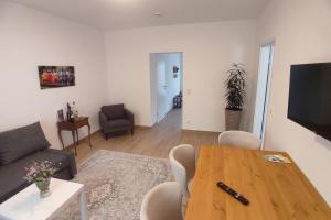 a living room with a wooden table and a couch at Storchennest - Ferienwohnung am Storchenradweg in Ketzür